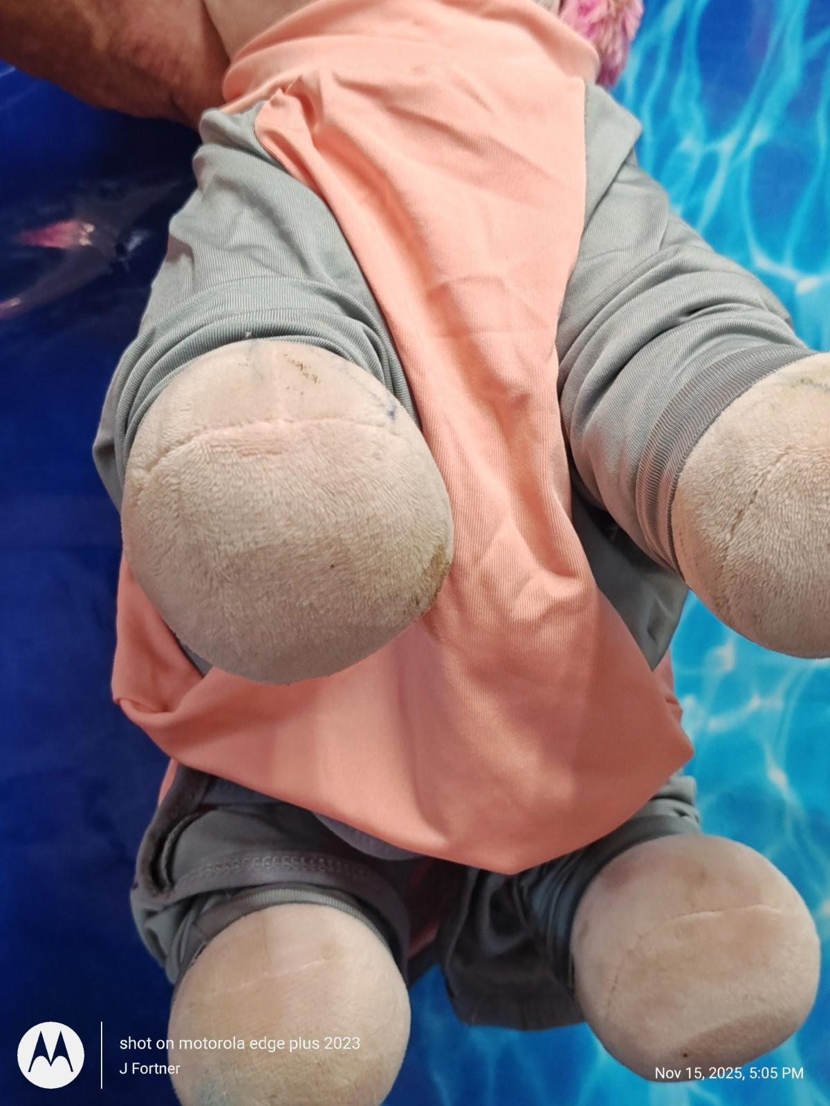 Plush Baby Doll with pink and gray outfit, featuring soft limbs and round feet.