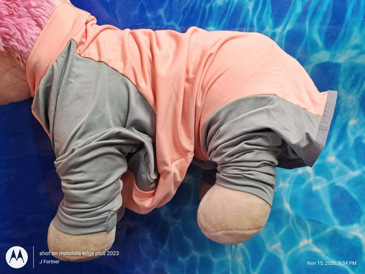 Plush toy wearing a pink and gray outfit, showcasing soft fabric and playful design.