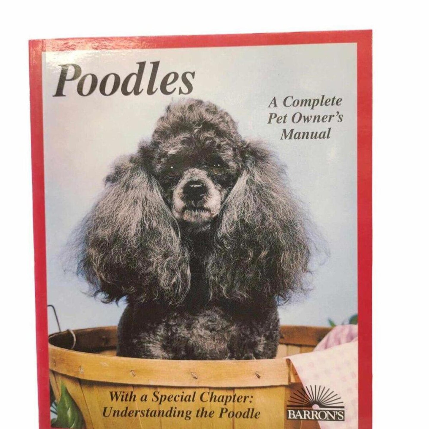 Poodles book cover featuring a poodle in a flower pot, offering pet care insights.