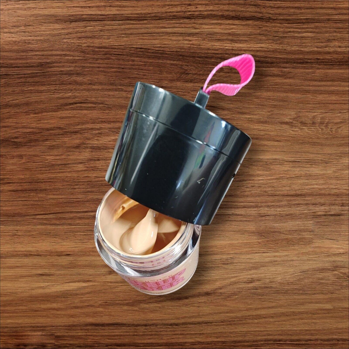Product name container with a black lid and pink pull tab, showcasing the contents inside.