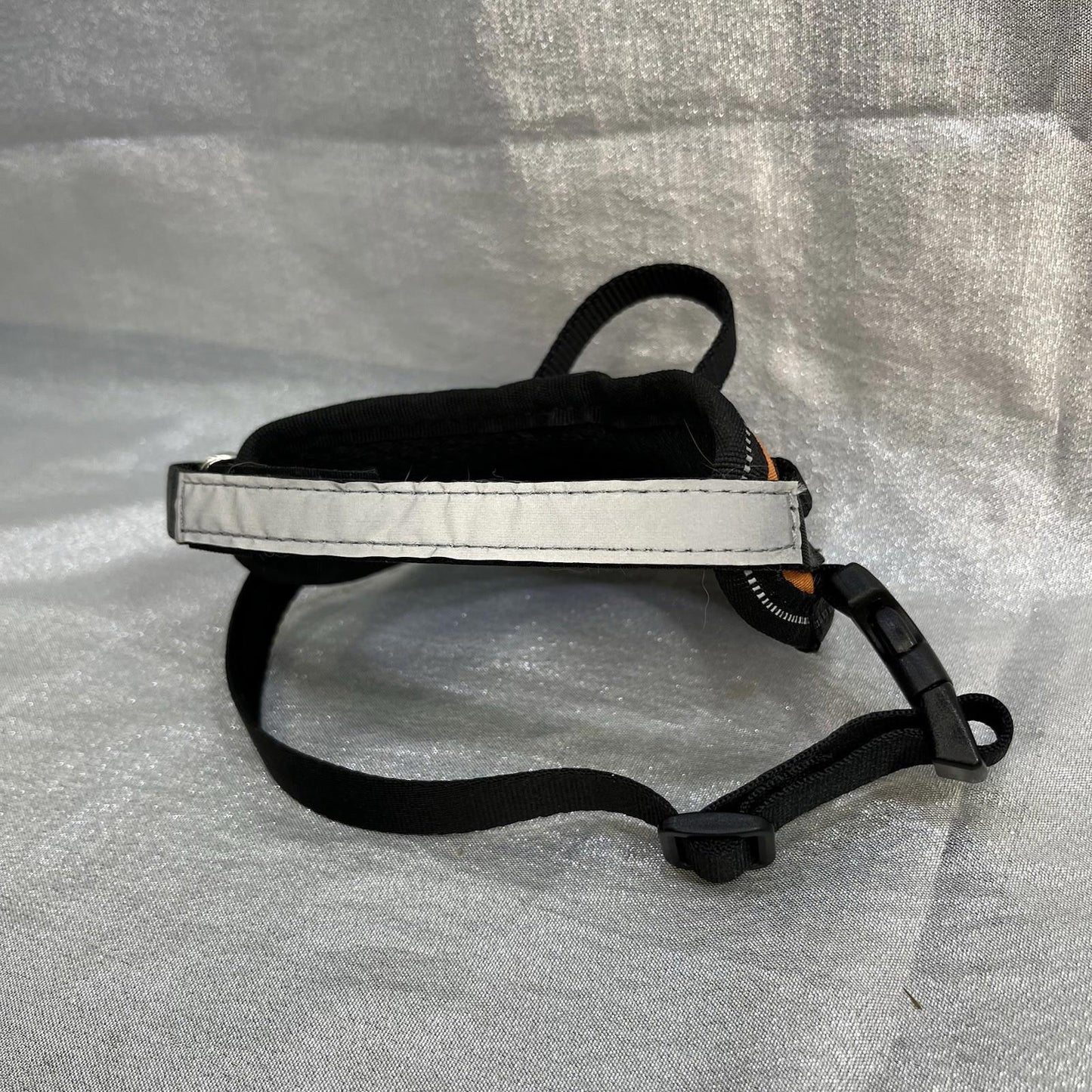 Dog harness with reflective strap for safety and comfort.