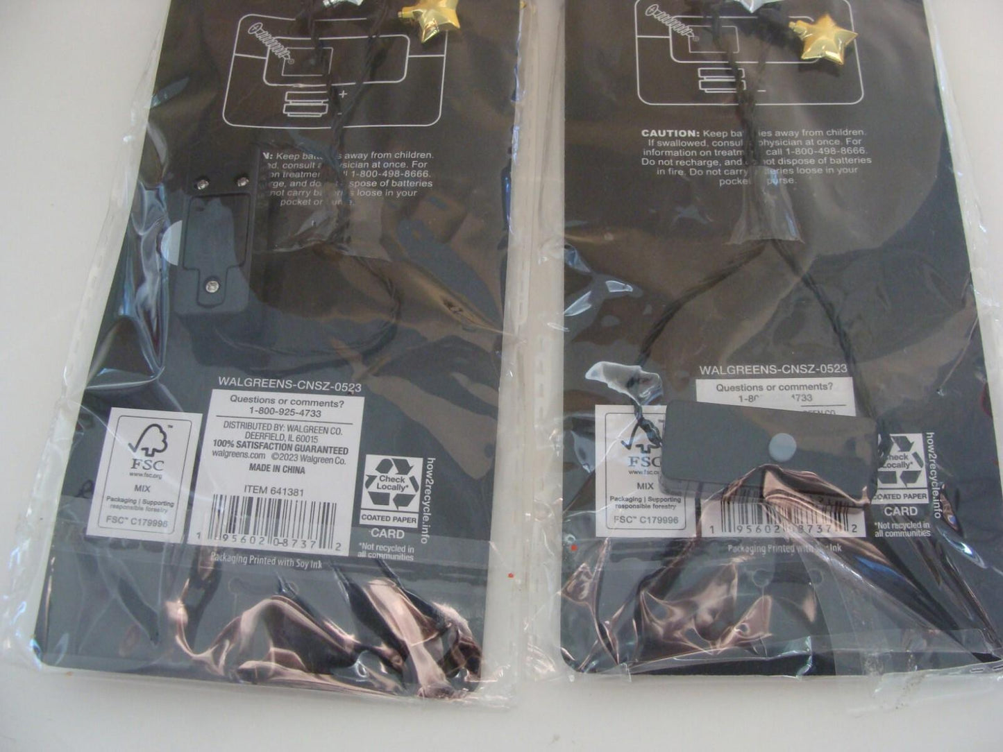 Product name not provided. Two black packaging items with labels and cords visible.