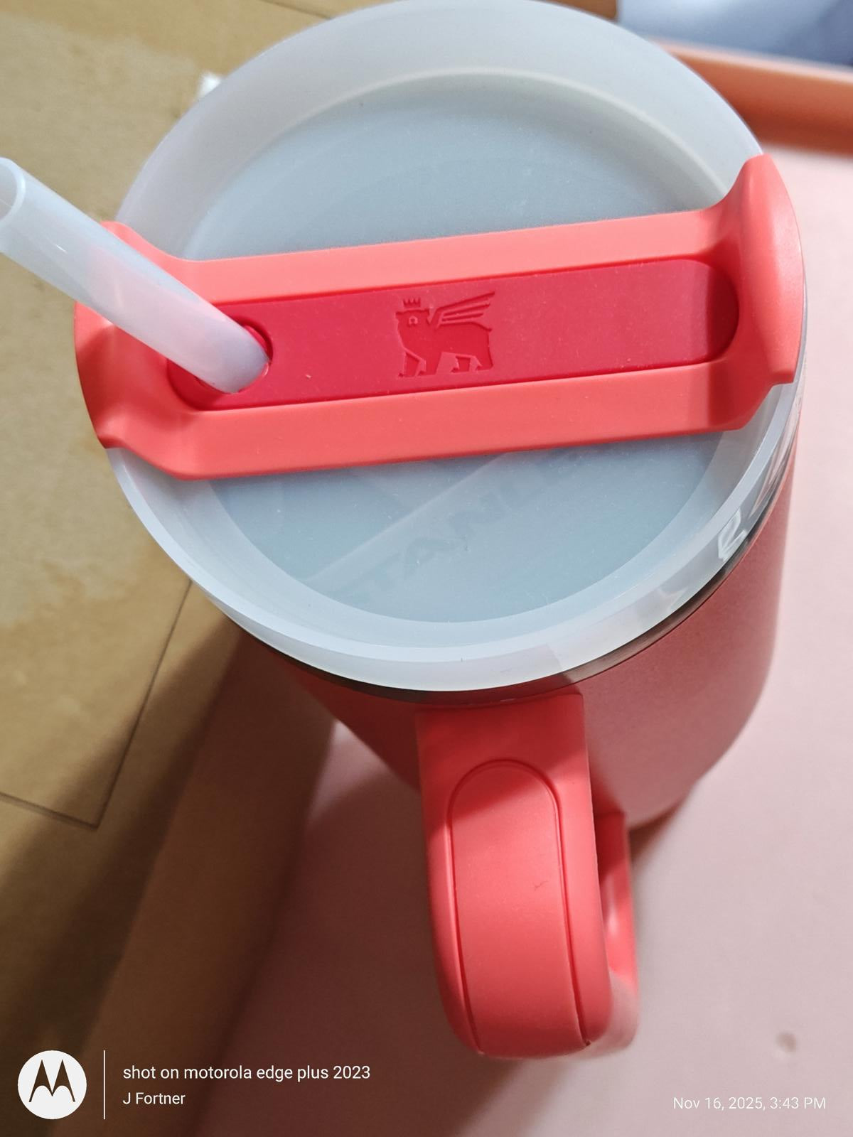 Red travel mug with a straw and a lion logo on the lid.