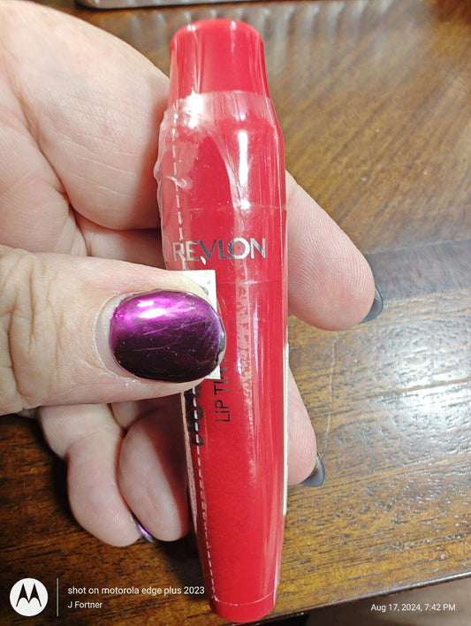 Revlon red lip crayon with a glossy finish held by a hand with purple nail polish.