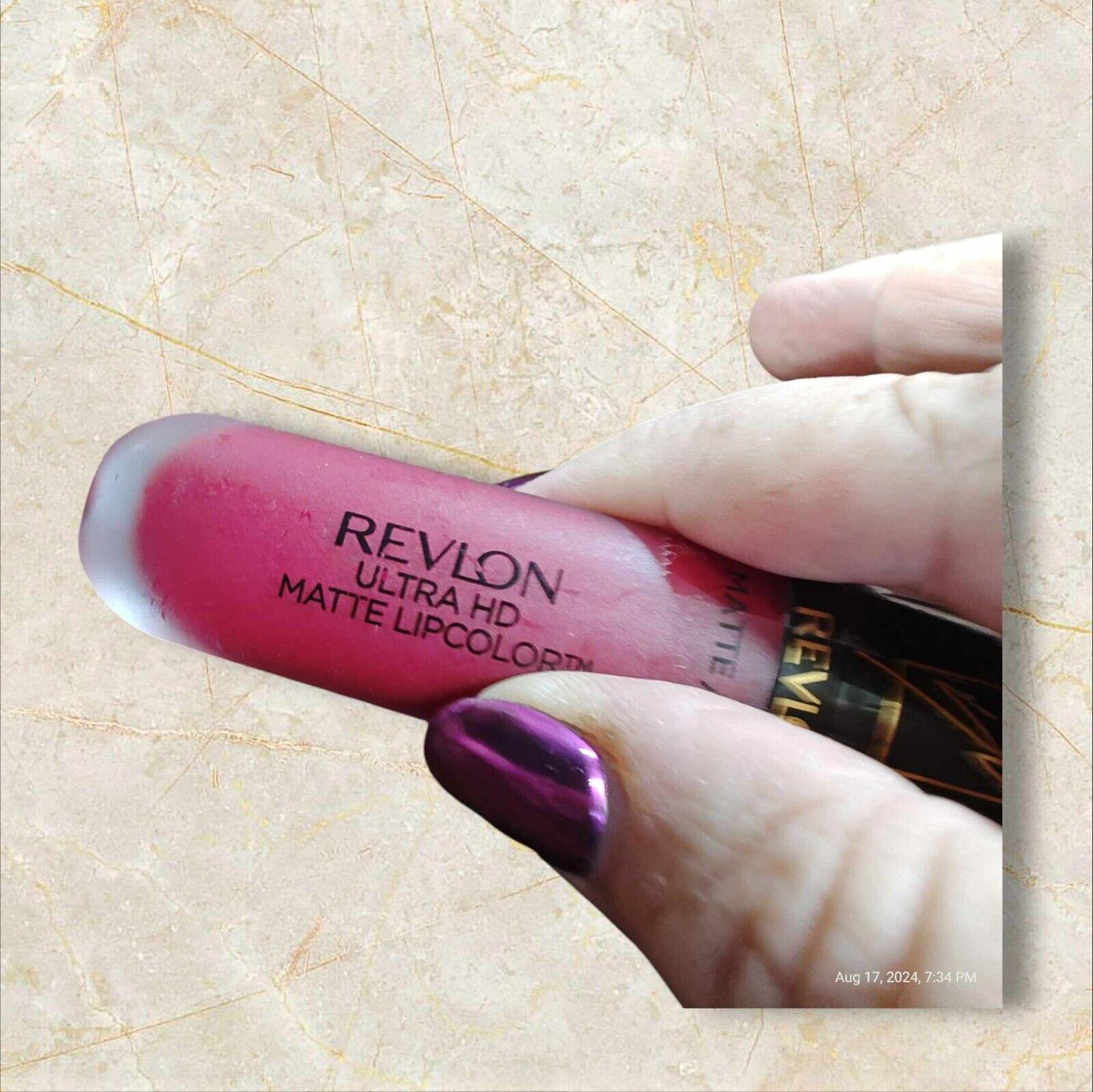 Revlon Ultra HD Matte Lipcolor in a vibrant pink shade held in hand.