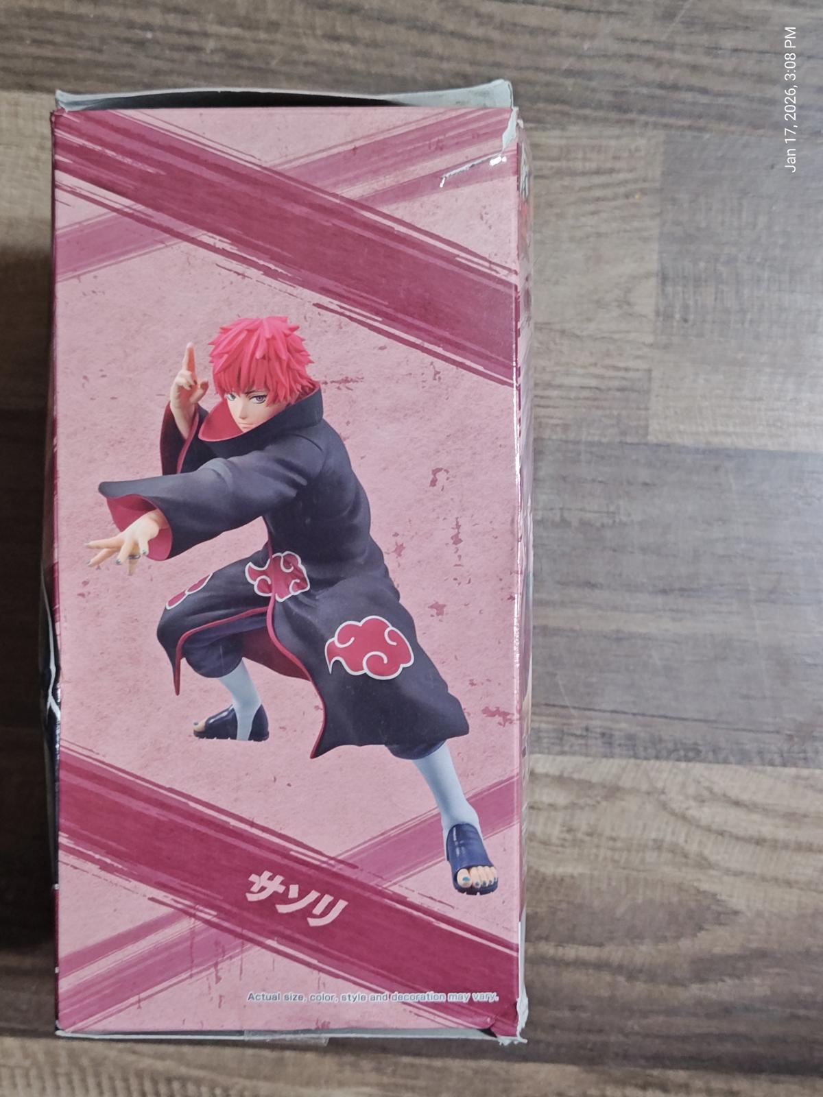 Sasori action figure from Naruto, featuring red hair and black outfit with Akatsuki symbols.