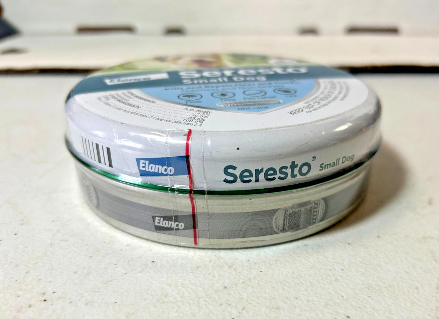 Seresto small dog flea and tick collar in a round tin container with clear labeling.