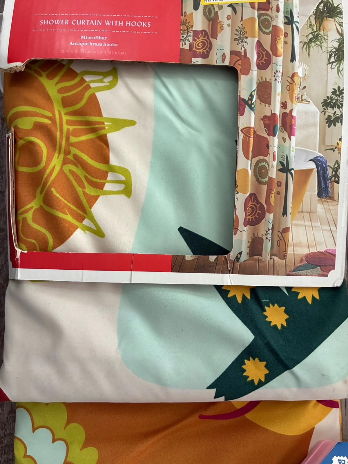Shower curtain with hooks featuring vibrant floral and sun designs in bright colors.