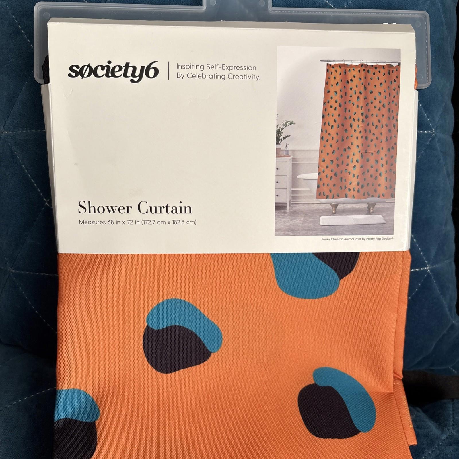 Society6 shower curtain featuring an orange background with blue and black abstract shapes.