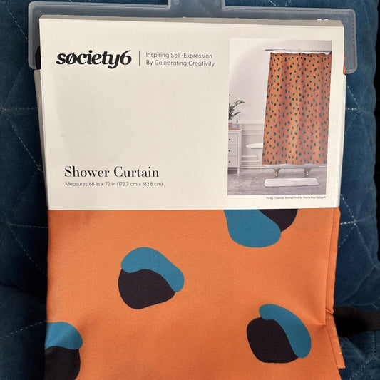 Society6 shower curtain featuring an orange background with blue and black abstract shapes.