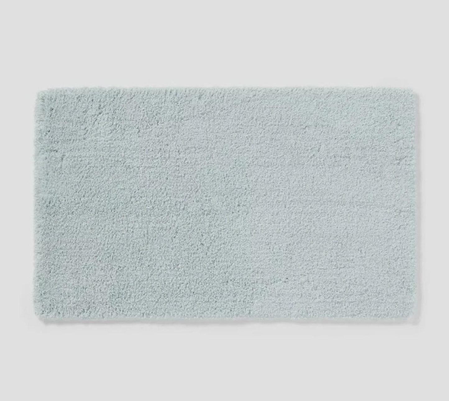 Soft aqua bath mat with plush texture for comfort and style.