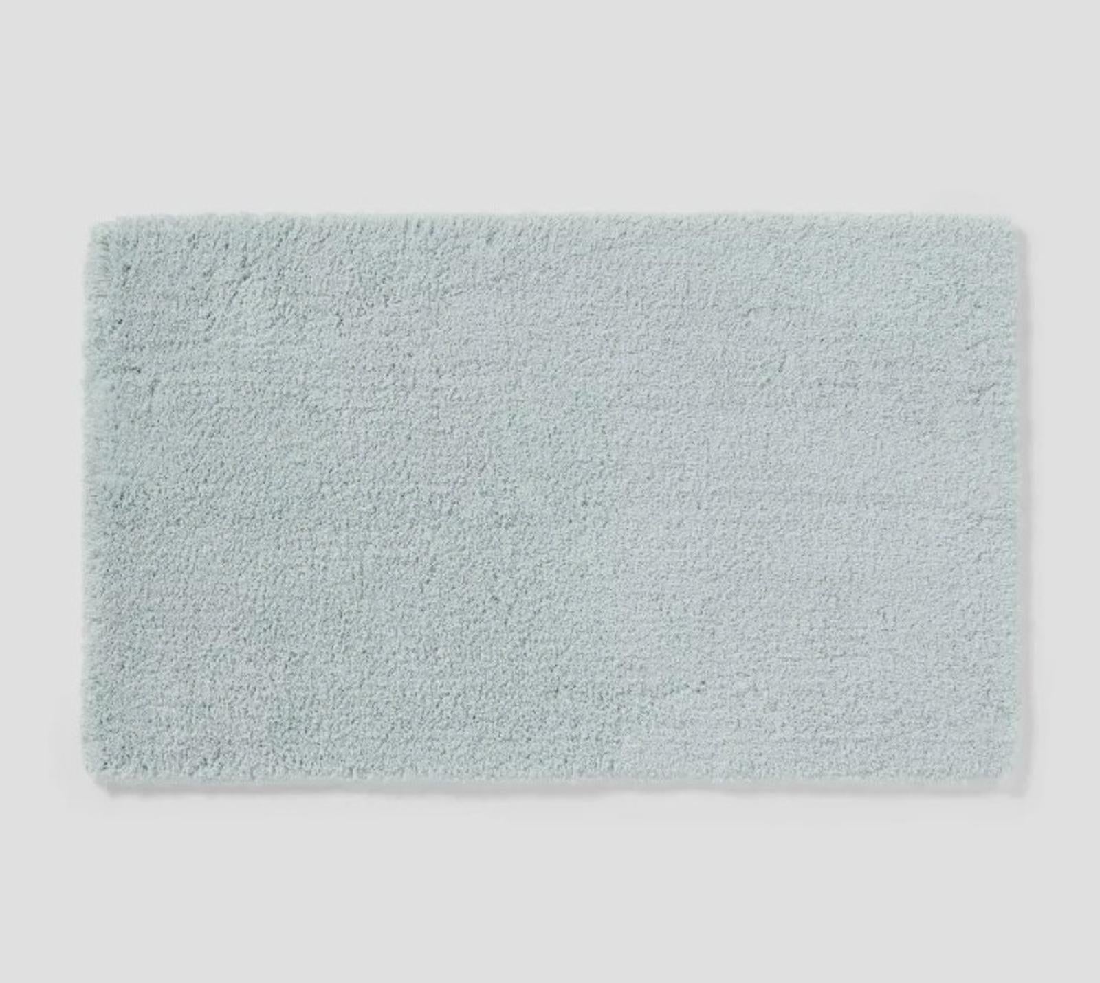 Soft aqua bath mat with plush texture for comfort and style.