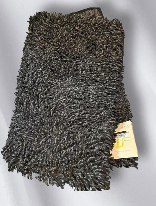 Soft black shaggy rug with a plush texture and tag attached.
