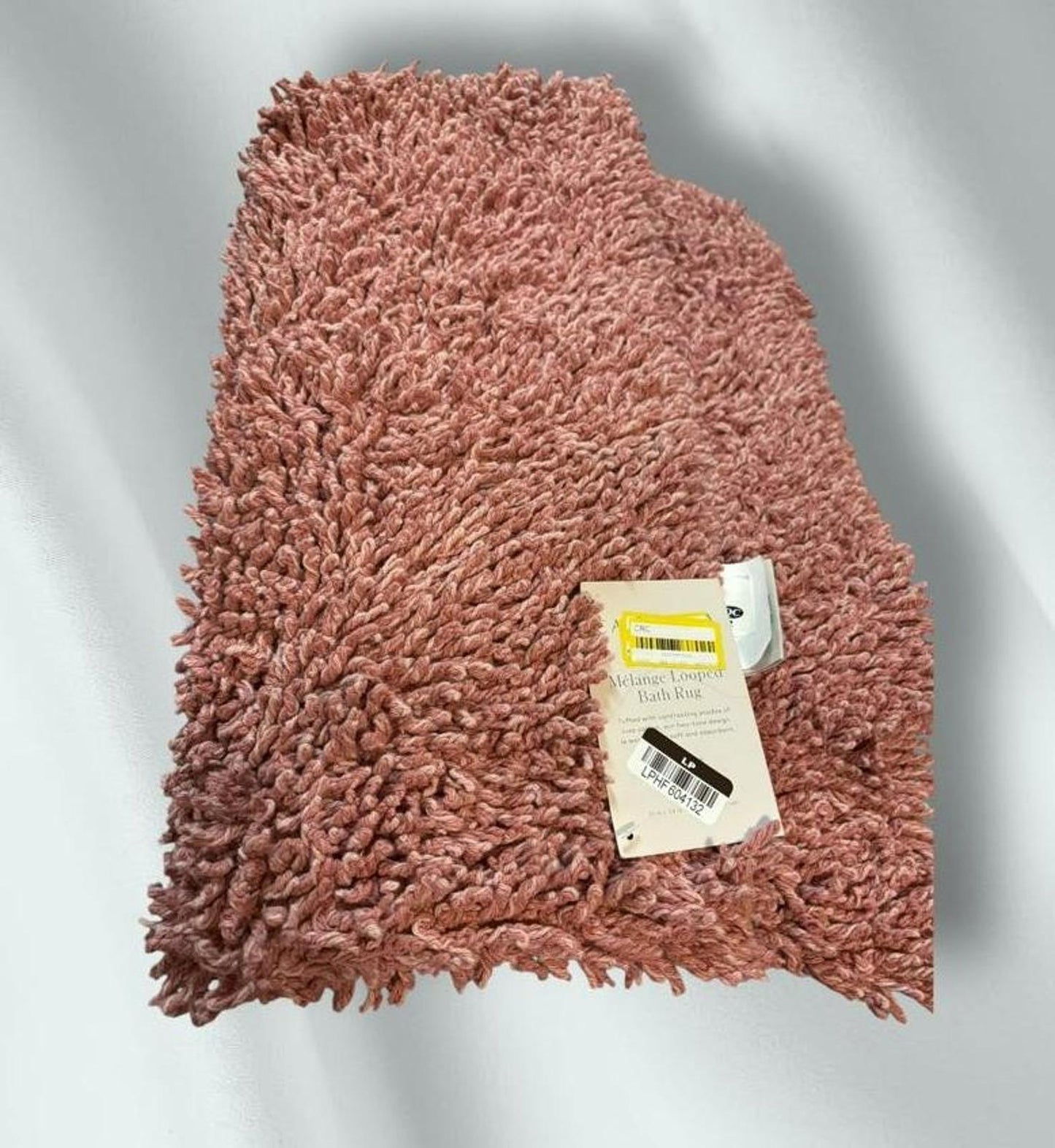 Soft pink shag rug with a plush texture and tag attached.