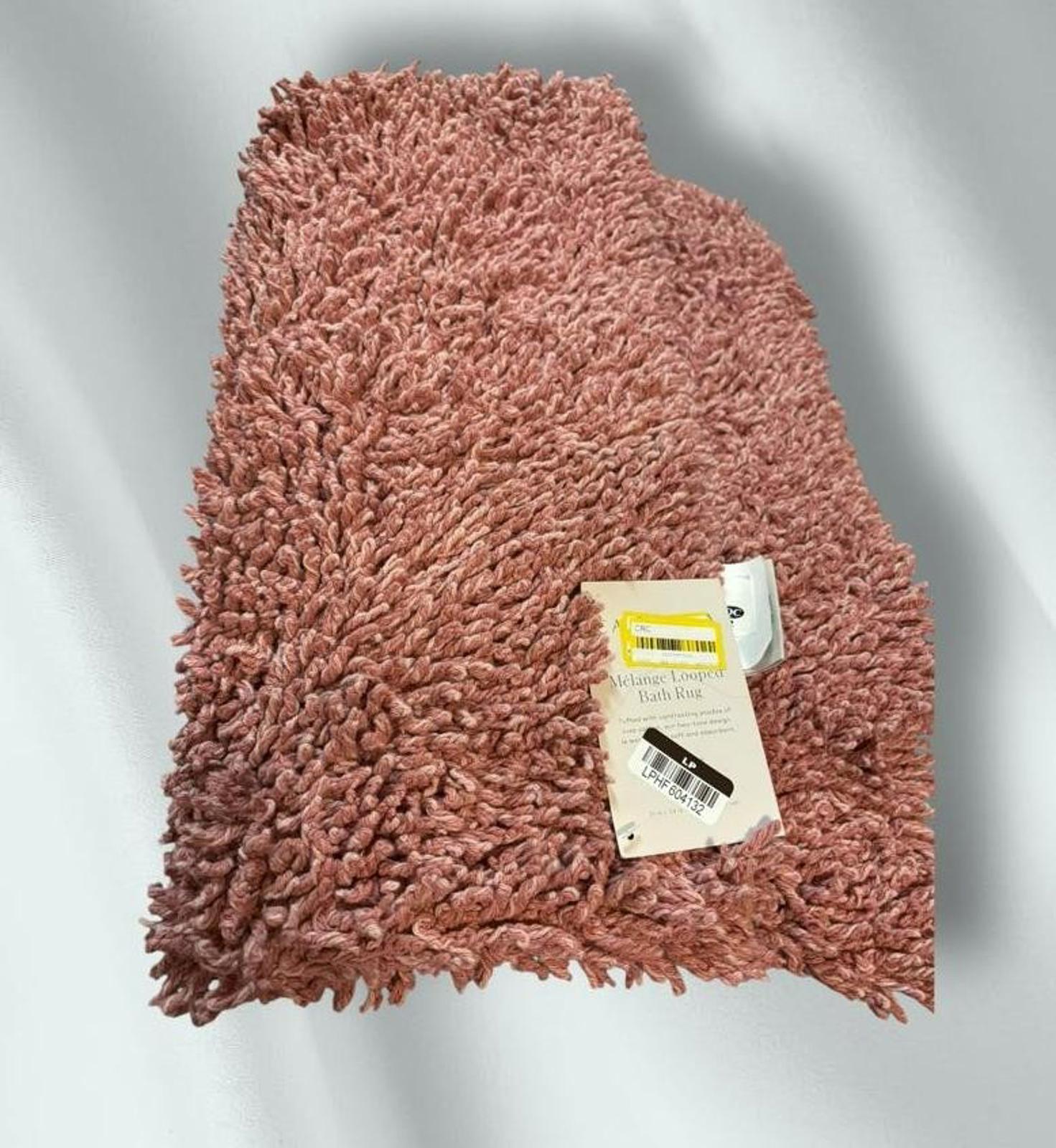 Soft pink shag rug with a plush texture and tag attached.