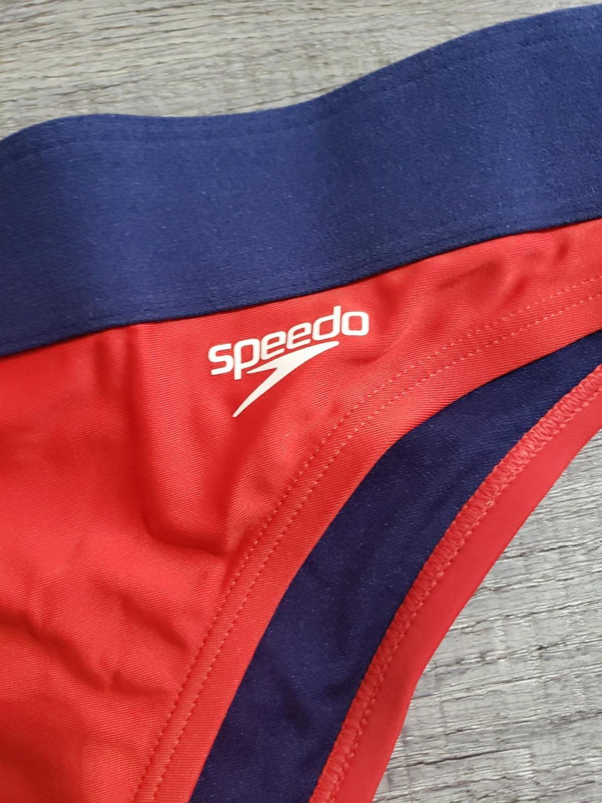 Speedo swimwear featuring a vibrant red and navy design with logo detail.