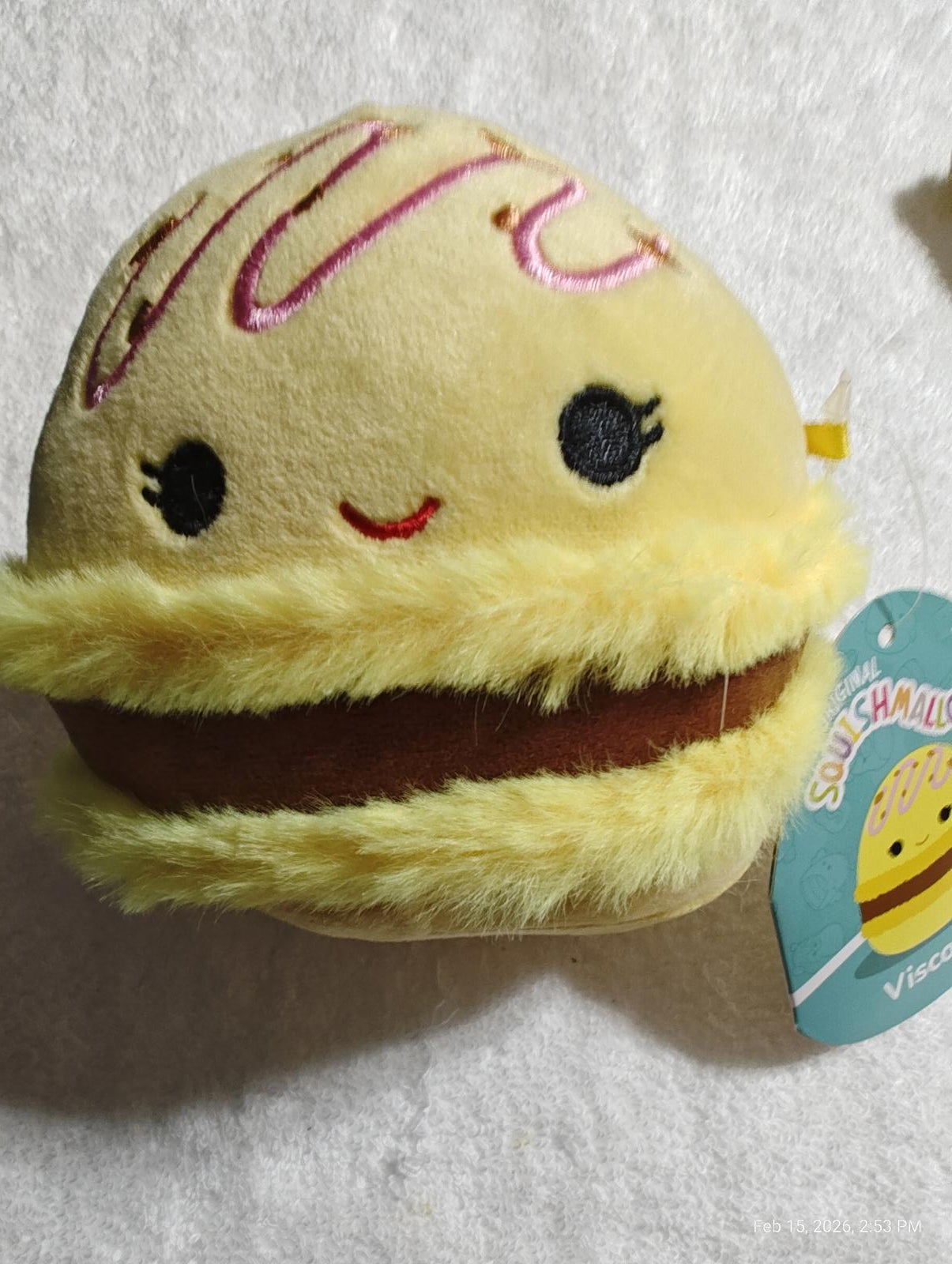 Squishmallow plush toy featuring a cute yellow macaroon design with a smiling face.