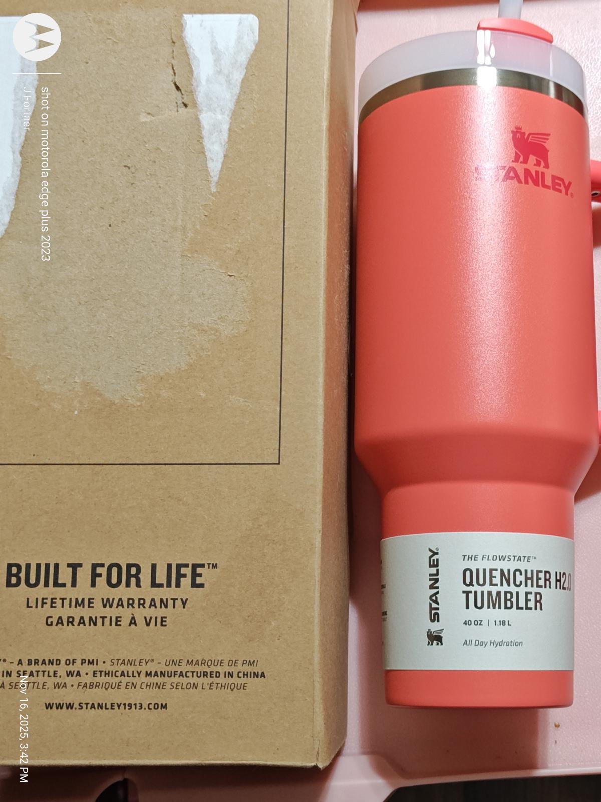 Stanley Quencher 40 oz tumbler in coral color with a lid, designed for durability and hydration.