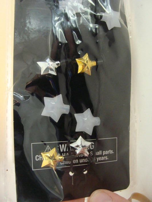 Star-shaped embellishments in silver and gold colors for crafting projects.