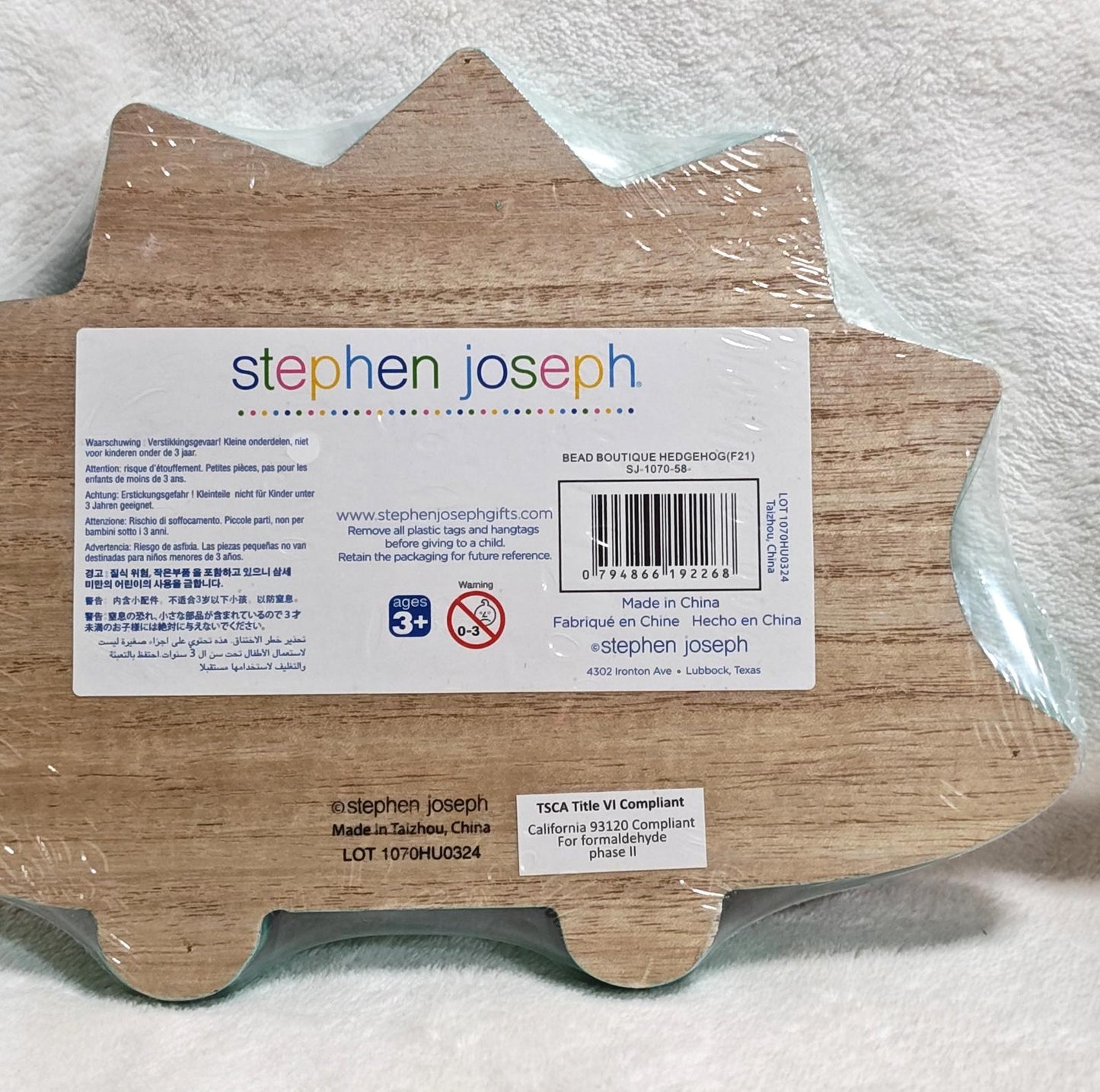 Stephen Joseph hedgehog-shaped wooden toy with colorful details and safety information.