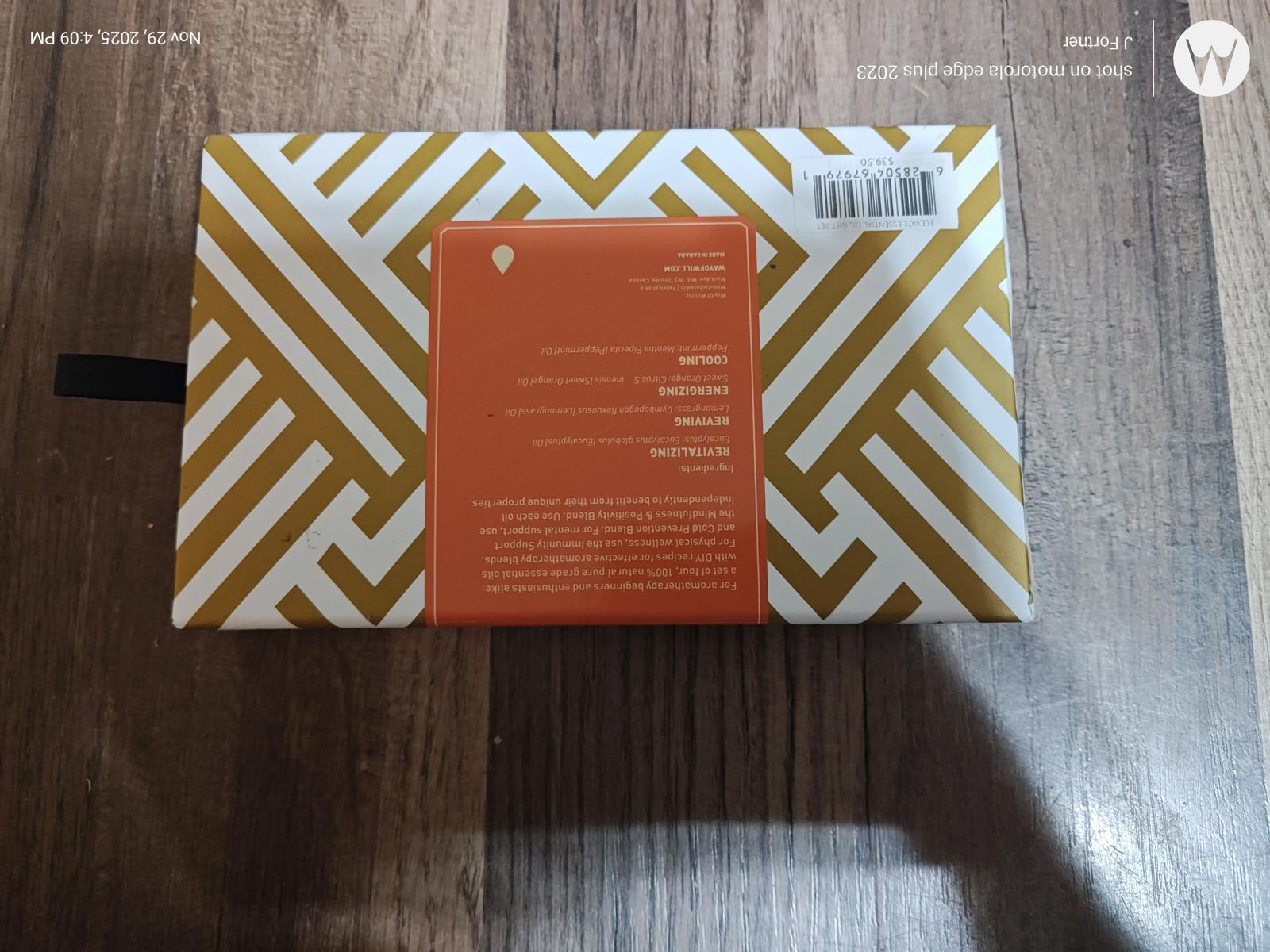Stylish geometric patterned notebook with gold and white design, featuring an orange label on the back.