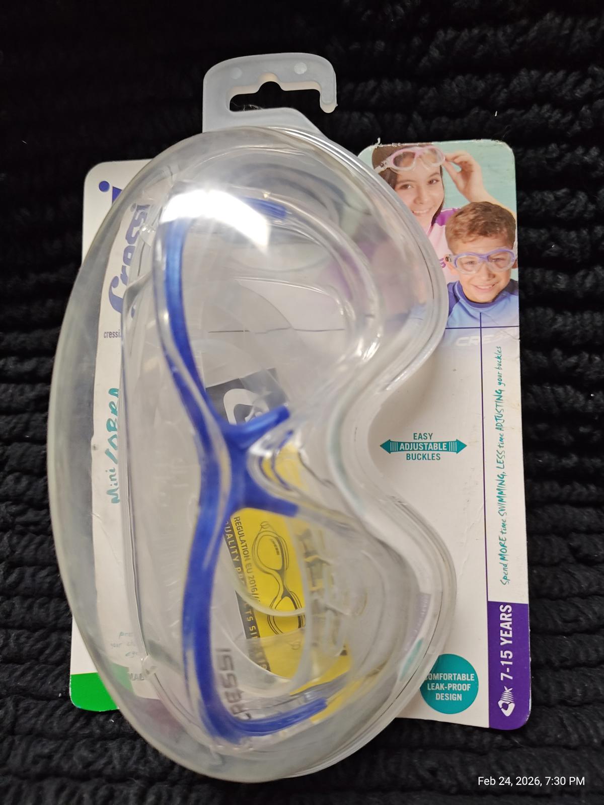 Swim Goggles with blue frame and clear lens, packaged for easy storage.