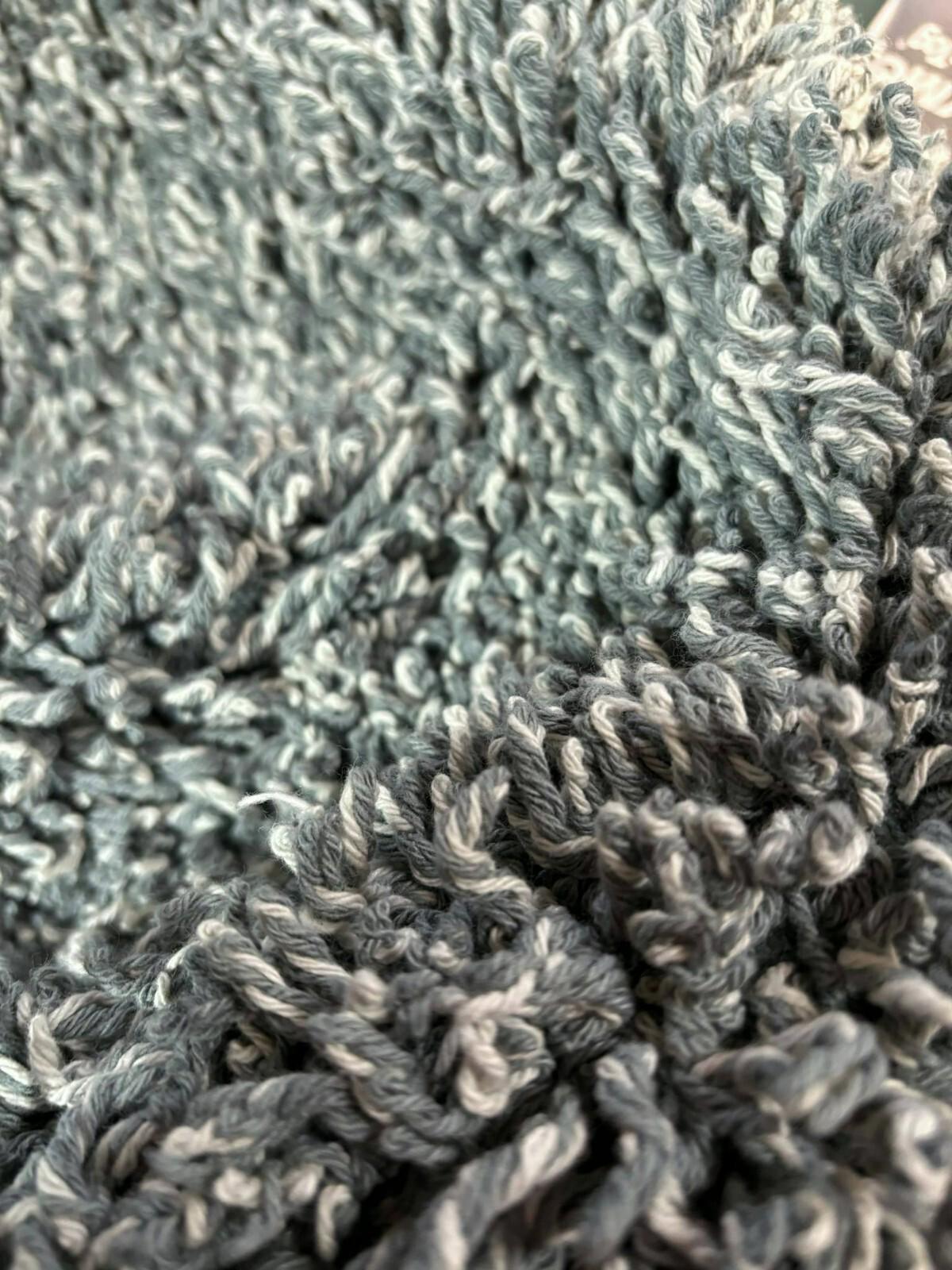 Soft teal shaggy rug with plush texture and intricate fibers.