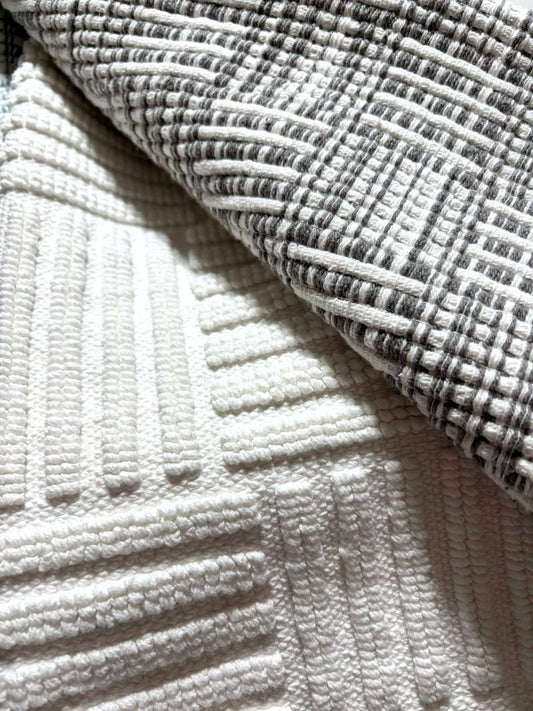 Textured white and gray blanket featuring a geometric pattern.