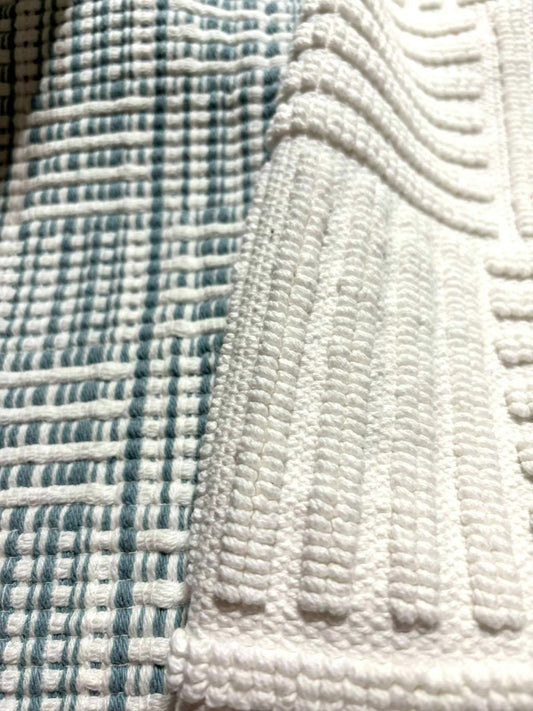 Textured cotton fabric in white and teal patterns for home decor.