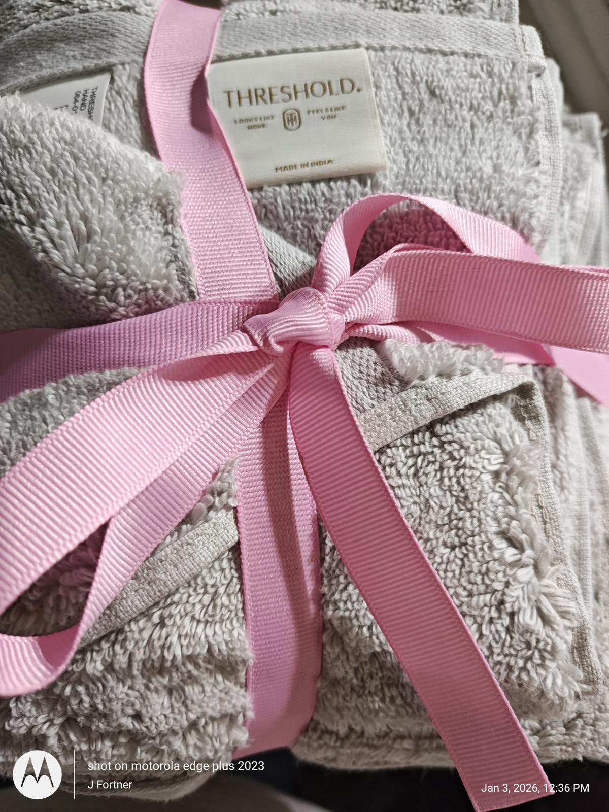 Threshold bath towels set wrapped with pink ribbon, featuring soft gray texture.