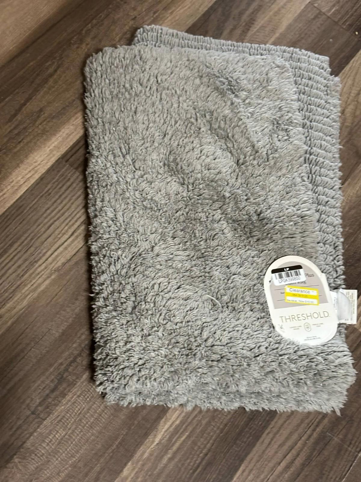 Threshold gray bath mat with plush texture and tag visible.