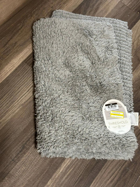 Threshold gray bath mat with plush texture and tag visible.