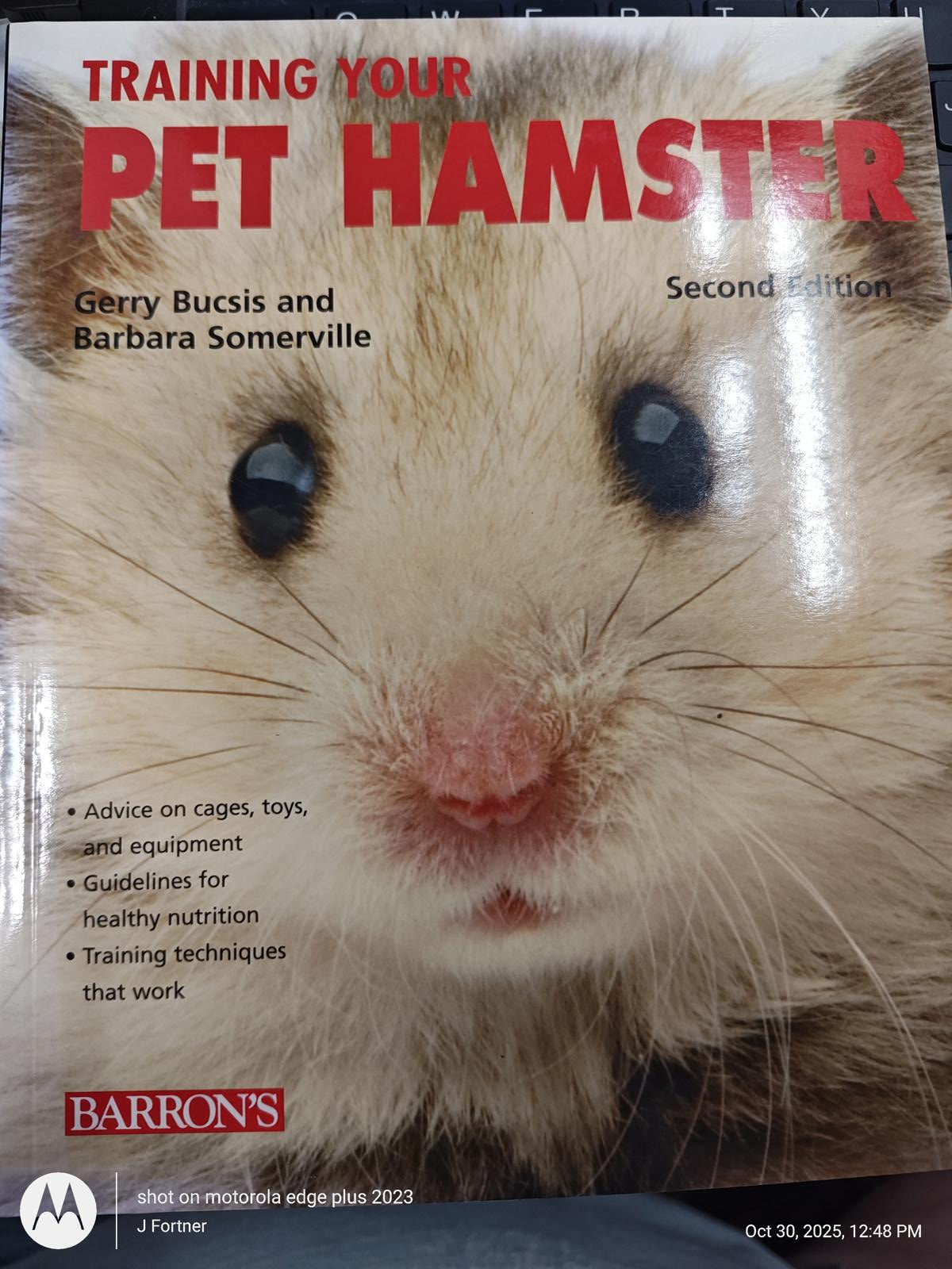 Training Your Pet Hamster book cover featuring a close-up of a hamster's face.