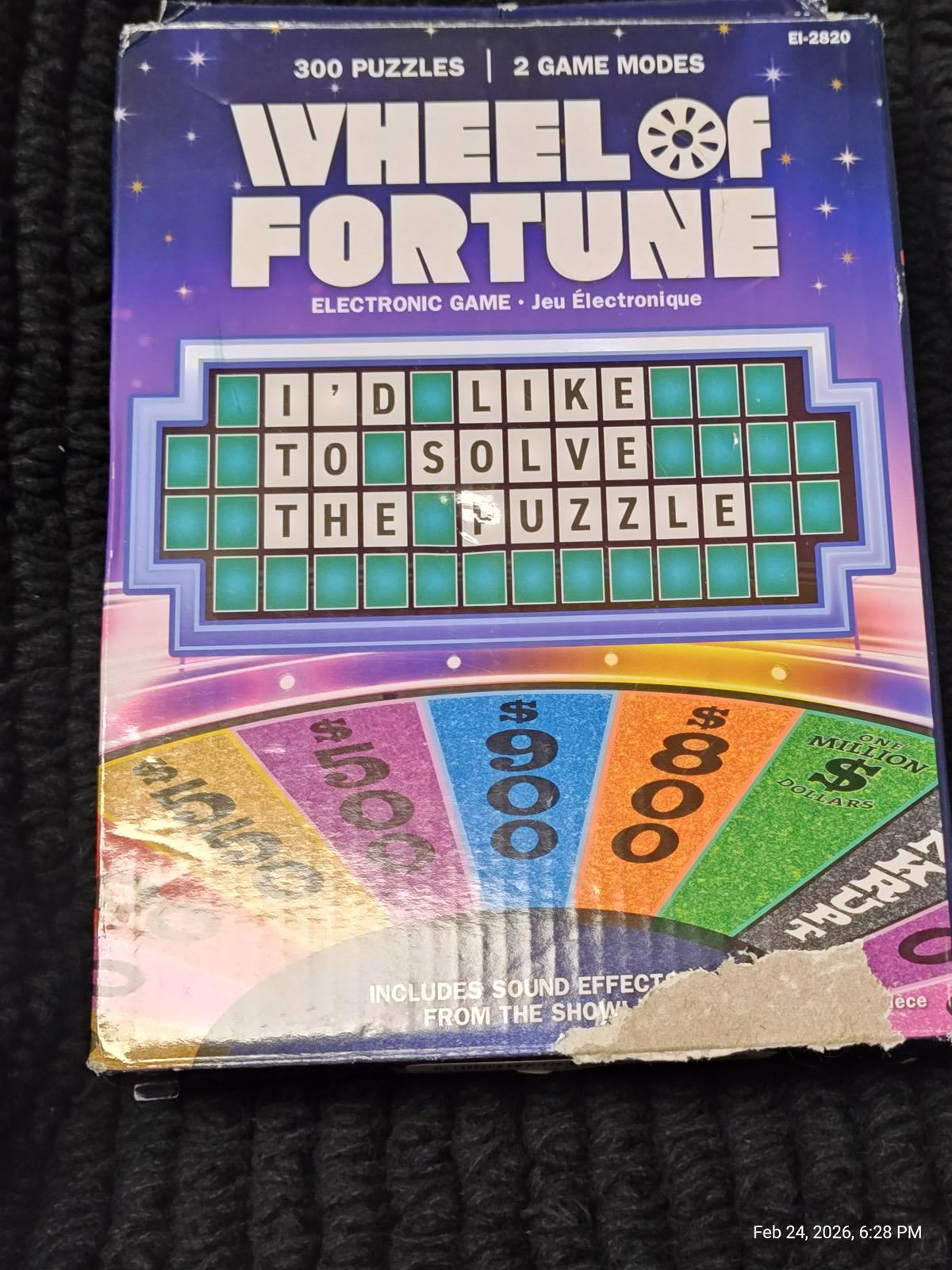 Wheel of Fortune electronic game box featuring colorful puzzle board and game modes.