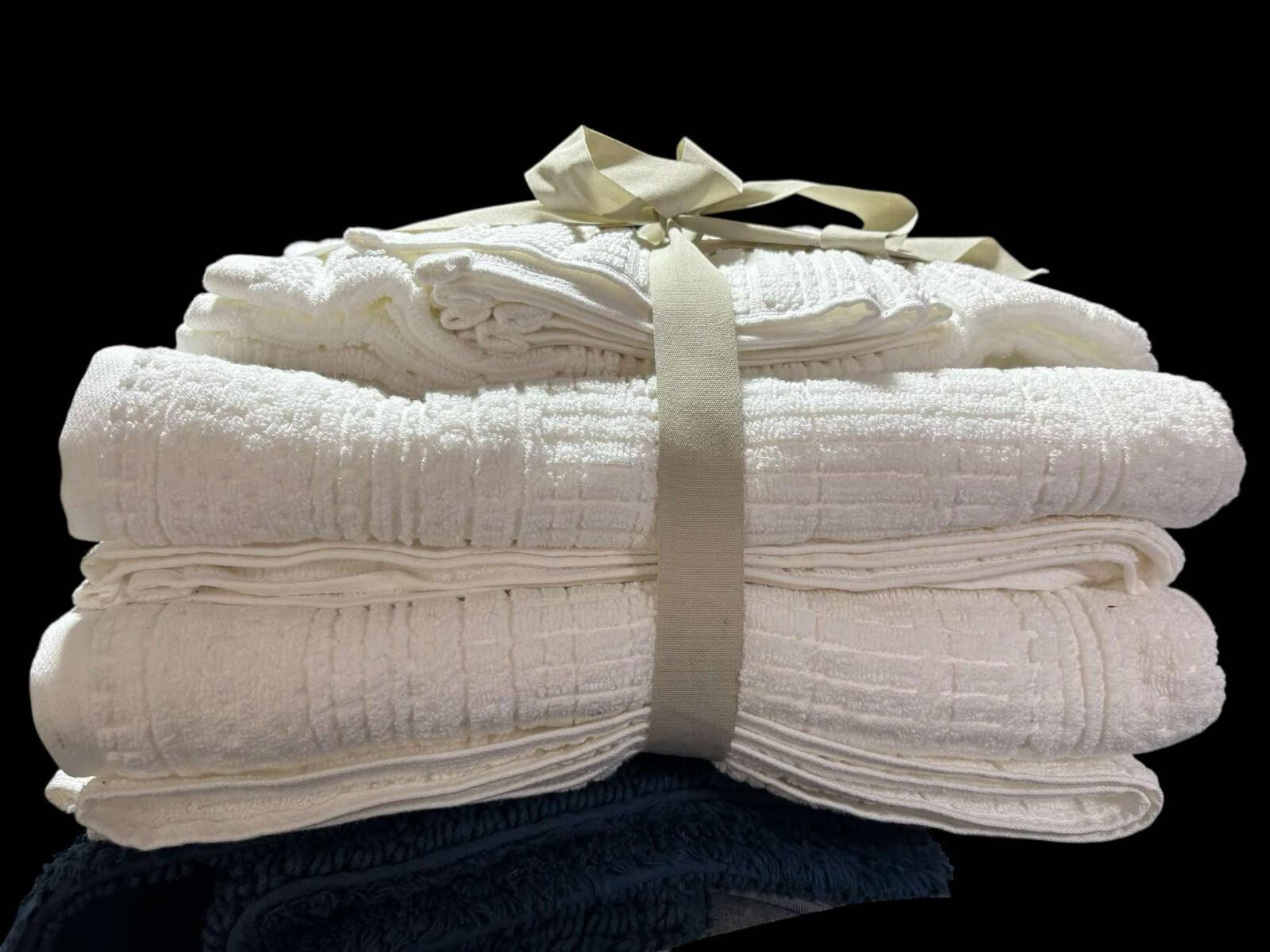 White cotton bath towels set neatly stacked with a ribbon.