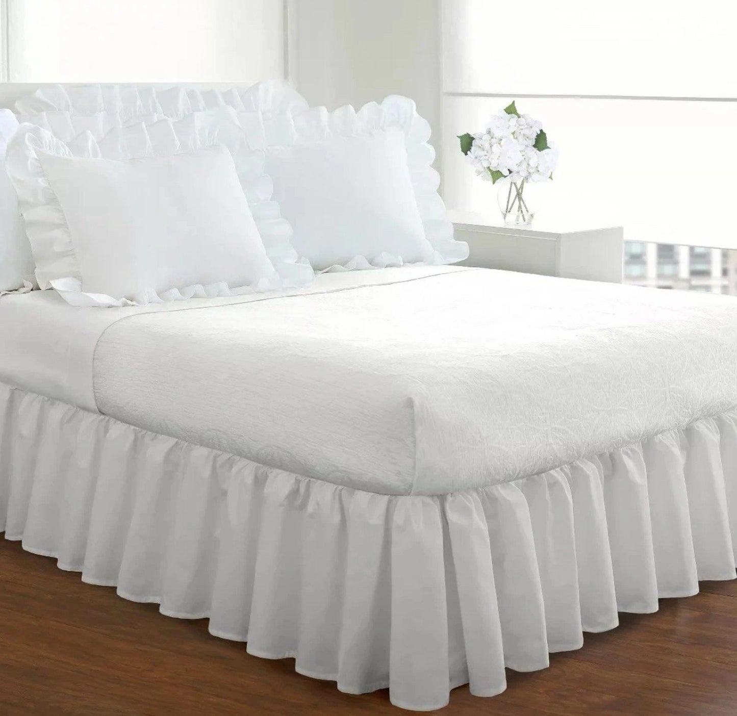 White Ruffled Bed Skirt with matching pillows on a neatly made bed.
