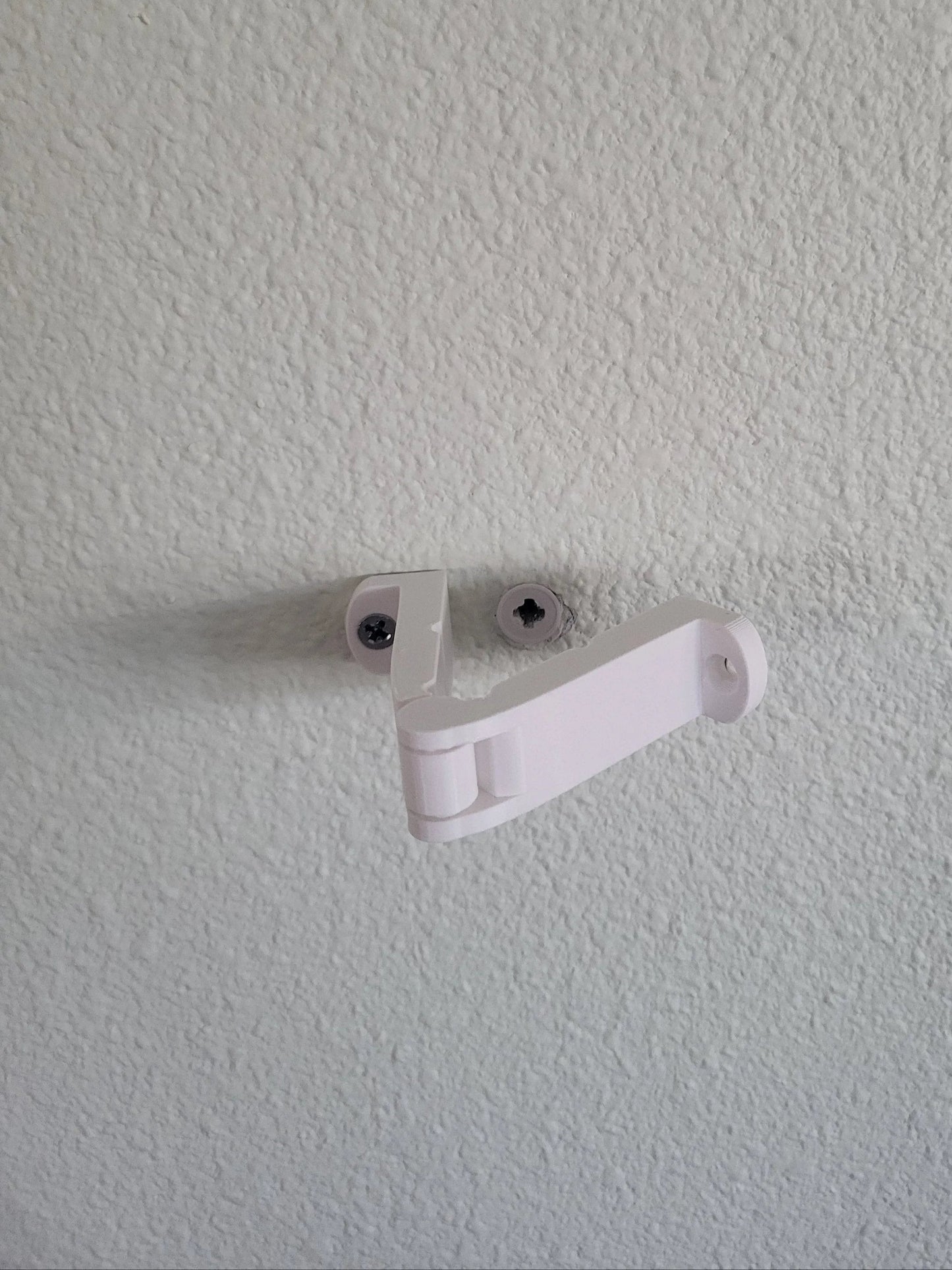 White wall hook designed for hanging items securely on walls.