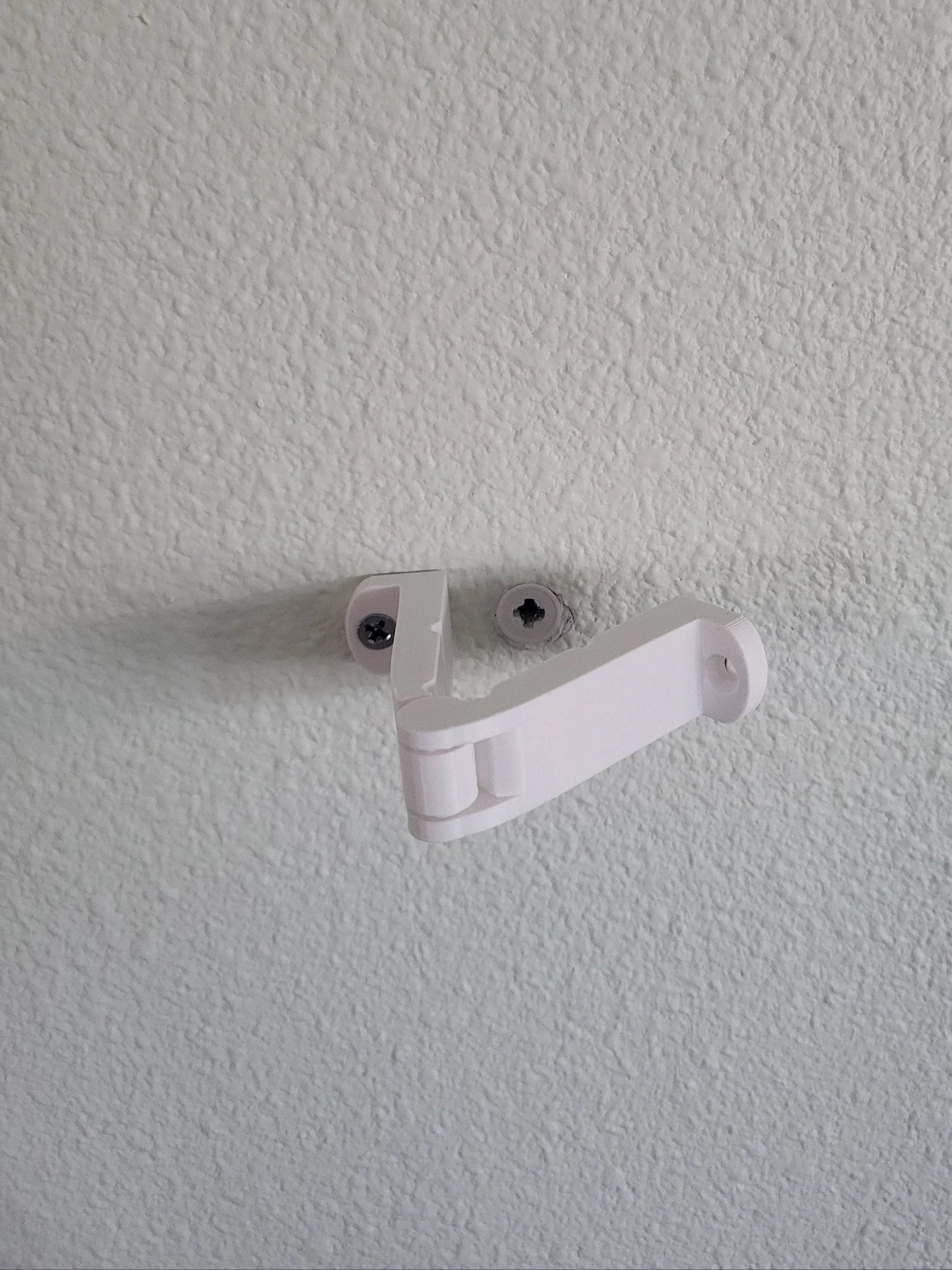 White wall hook designed for hanging items securely on walls.