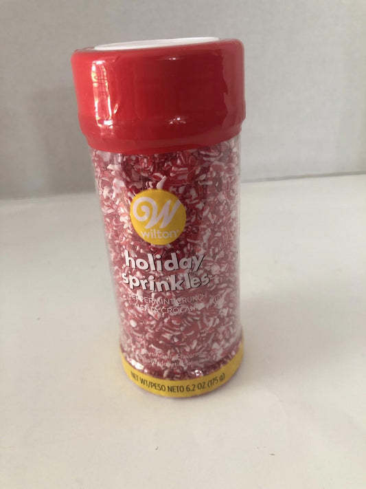 Wilton holiday sprinkles in a red container, perfect for festive baking and decorating.