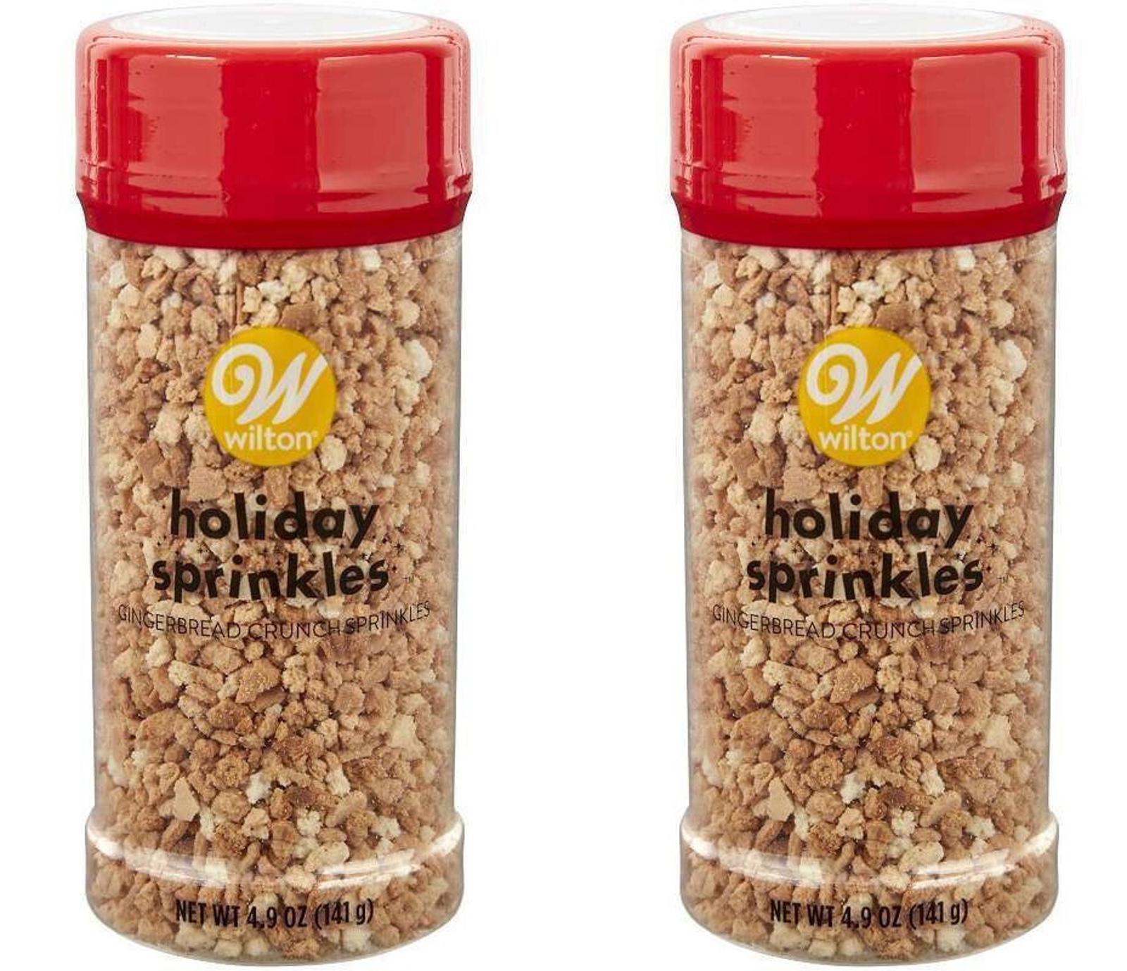Wilton holiday sprinkles in two containers, featuring red lids and colorful sprinkles inside.