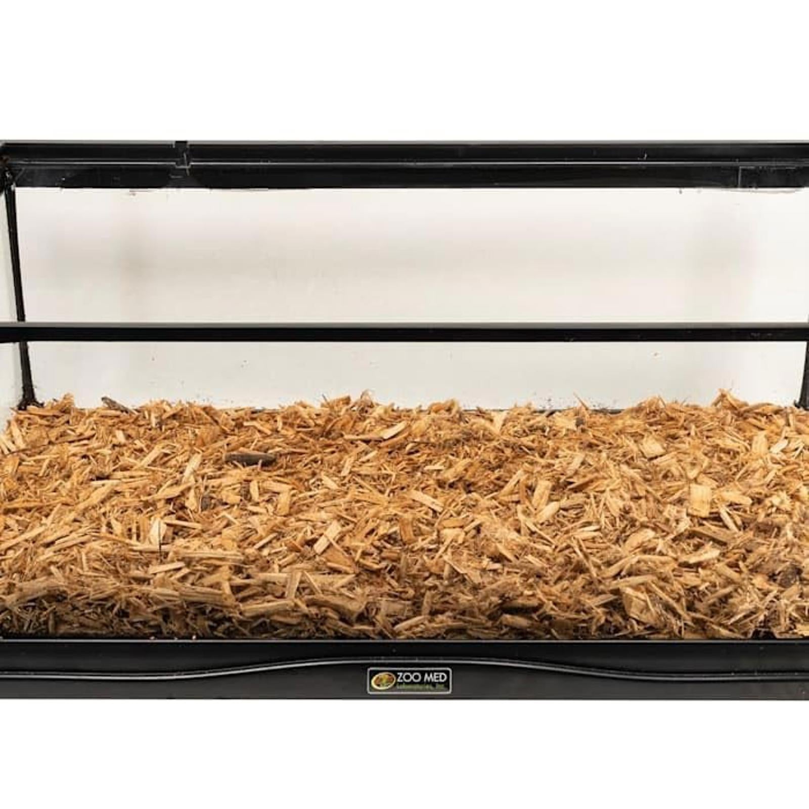 Wooden bedding for small animals in a black enclosure, providing a comfortable habitat.
