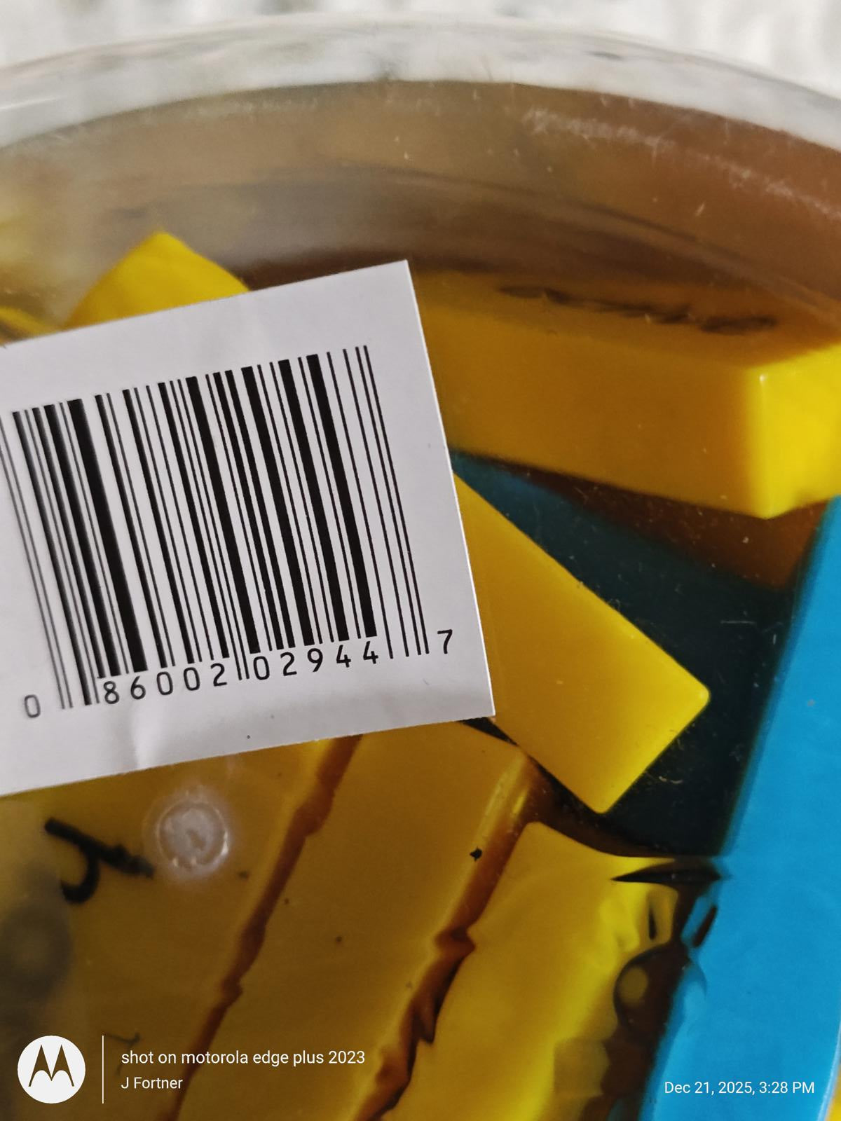 Product with yellow components submerged in water, featuring a barcode.