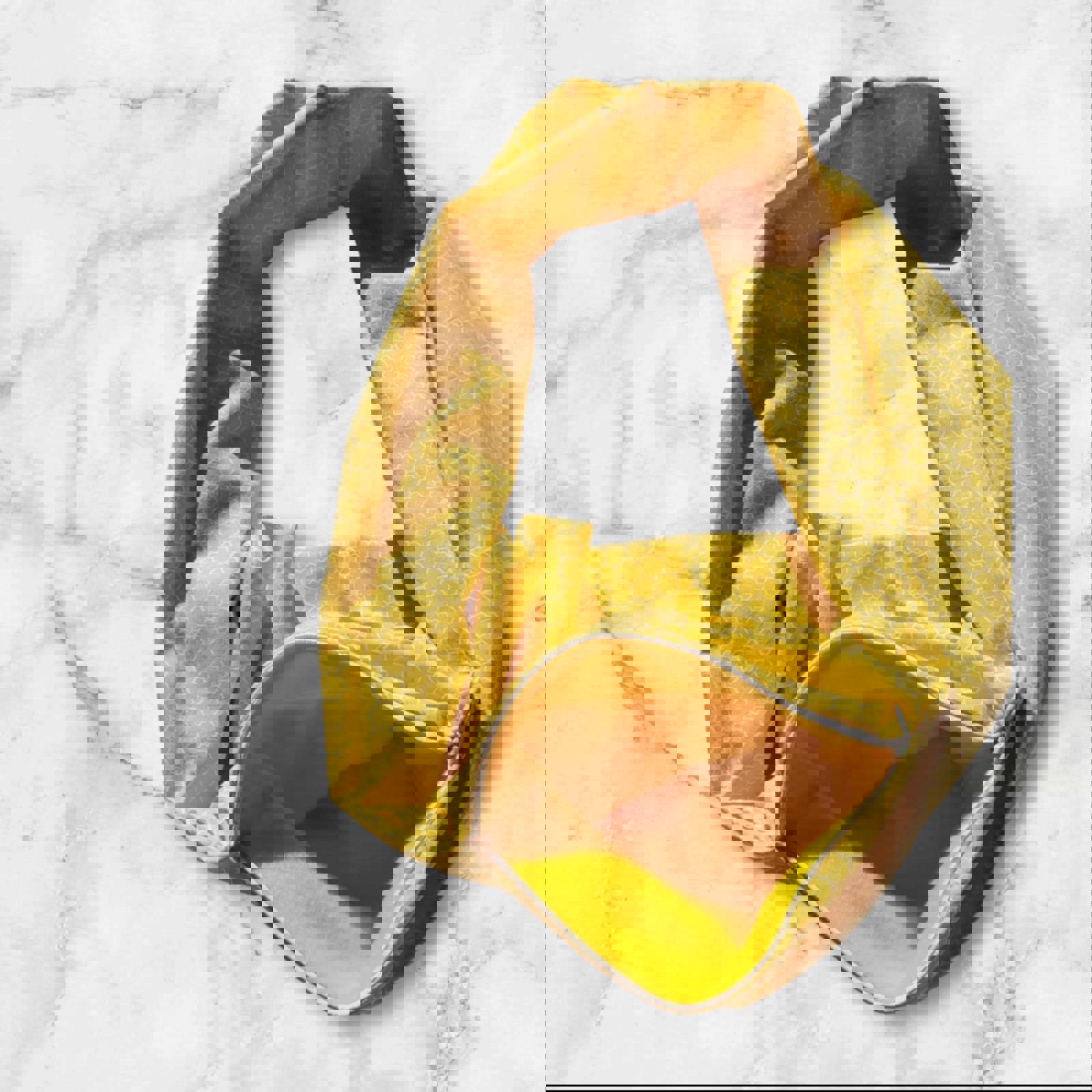 Yellow patterned tote bag with a zipper pocket, perfect for everyday use.